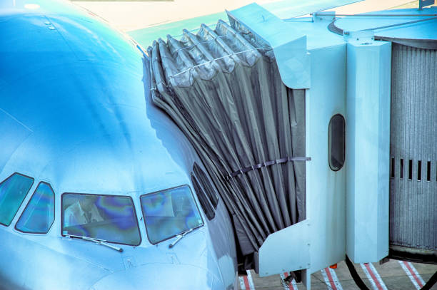 Airliner plane parked at the terminal view from the front cockpit fuselage with boarding bridge