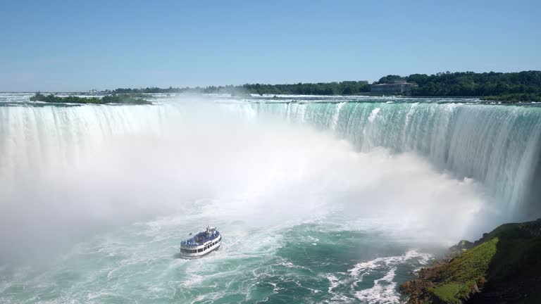Tourist Boat Approaching Famous Horseshoe Waterfall at Niagara Falls on the Border of United States and Canada