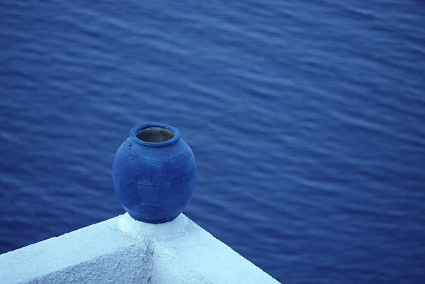 A blue pottery vase perched on a balcony edge, Santorini, Greece.