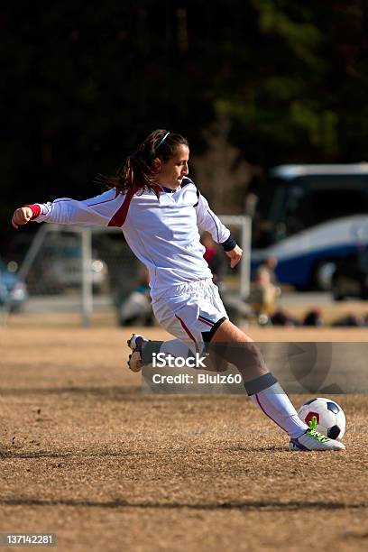 Mujer Jugador De Fútbol Sextiende Hasta Patear Pelota Foto de stock y más banco de imágenes de Fútbol femenino