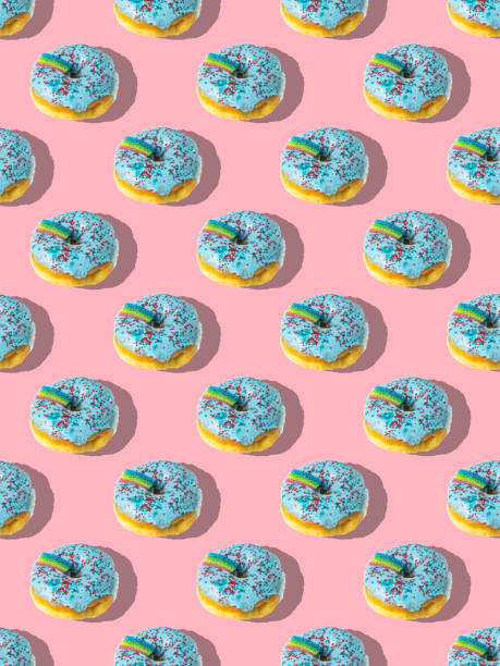 istock A repeating pattern of blue donuts with a rainbow on a pink background 1371428165