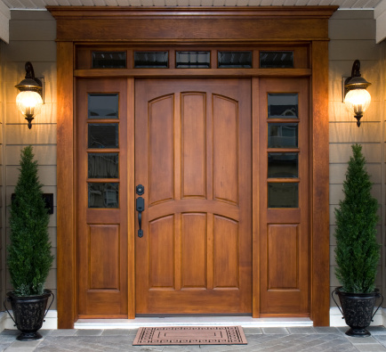 A beautiful wooden door graces the entrance to a west coast contemporary home.
