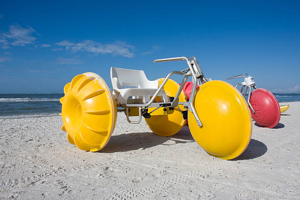 Water Tricycles, Ft. Myers Beach, Florida Colorful red and yellow water tricycles await riders along the beach in Ft. Myers Beach, Florida. pedal boat stock pictures, royalty-free photos & images