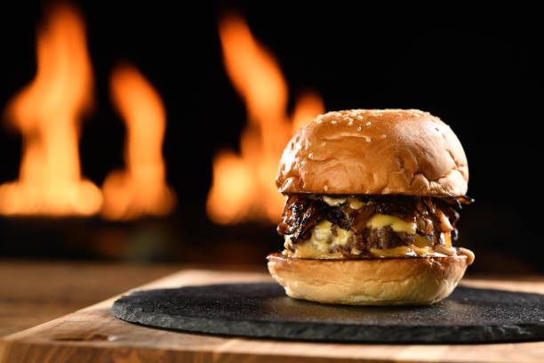 istock Beef cheeseburger on black plate with flames in background 1371431475