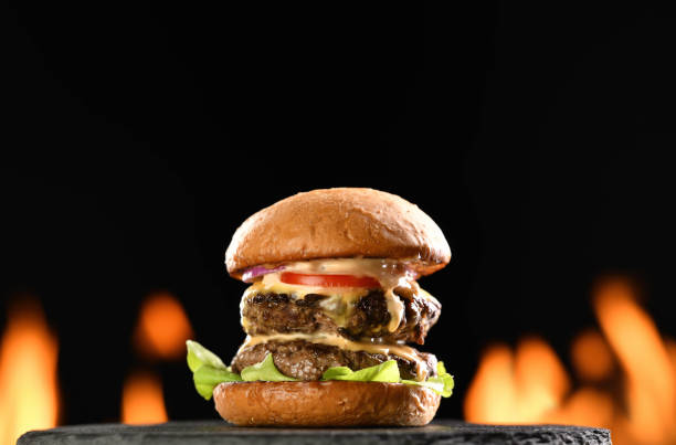 istock Beef cheeseburger on black plate with flames in background 1371431485