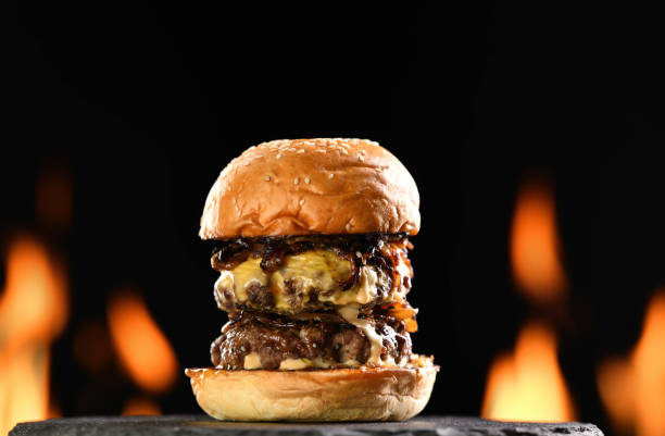 istock Beef cheeseburger on black plate with flames in background 1371431487