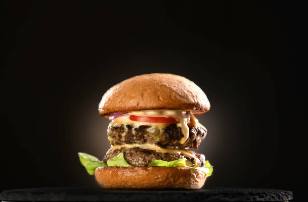 istock Beef cheeseburger on black plate on black background 1371431502