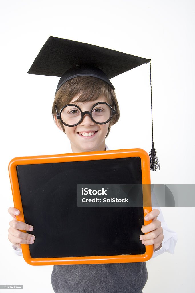 Scholar wearing a mortarboard Scholar wearing a mortarboard and holding a blackboard Boys Stock Photo