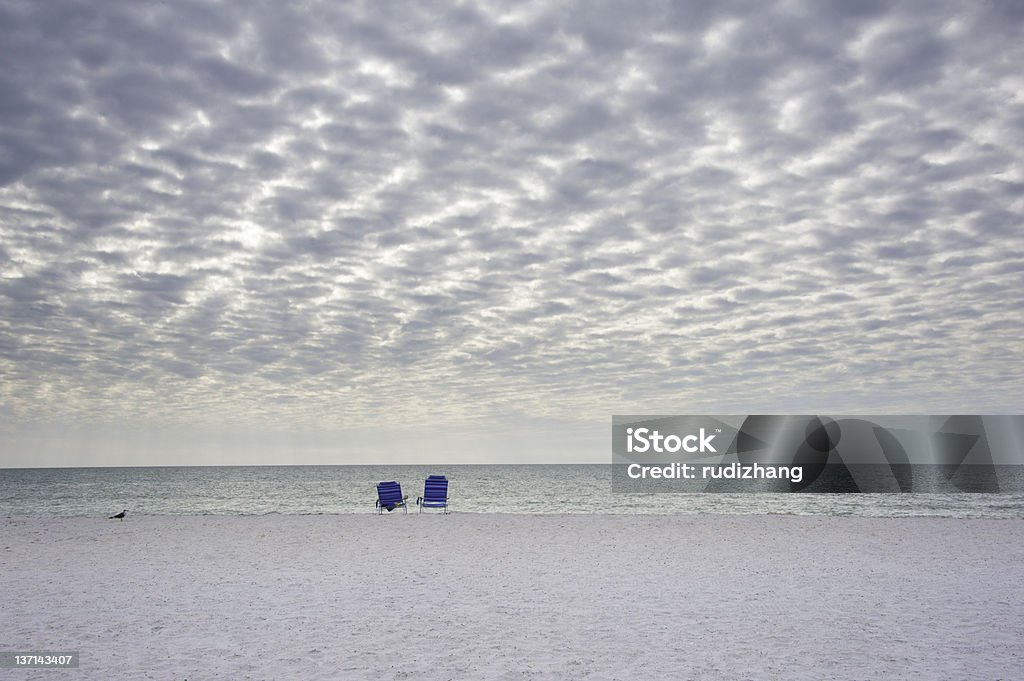 The White Sand Beach One bird an two chairs on a white sand beach in Florida. Beach Stock Photo