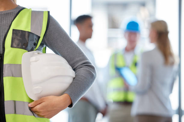 istock Cropped shot of an unrecognizable female construction worker standing with her hardhat under her arm and her colleagues in the background 1371434279