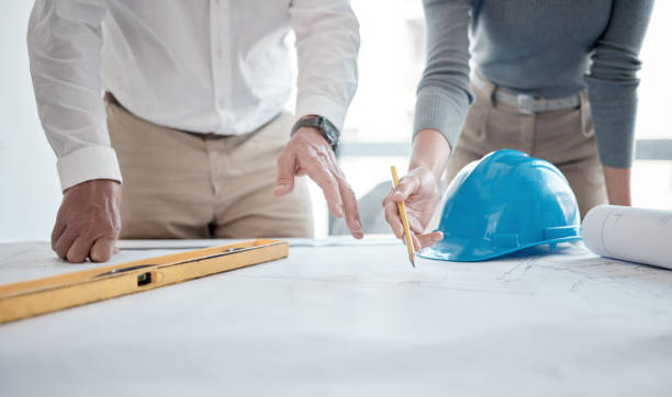 istock Cropped shot of two unrecognizable architects looking over blueprints in the office 1371434281