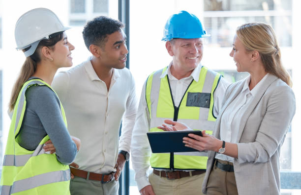 istock Cropped shot of four construction workers looking over a tablet while having a meeting 1371434292