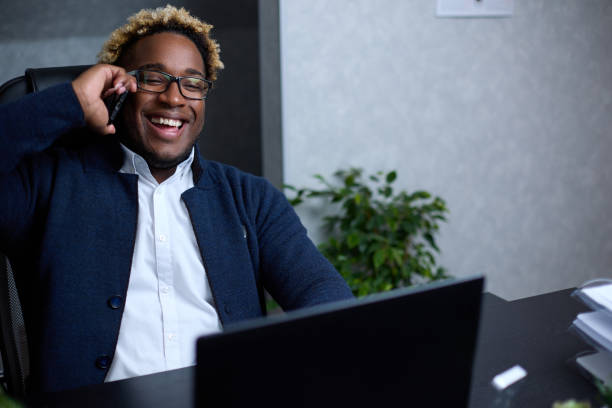 istock Smiling friendly African man talking on phone in office 1371440068
