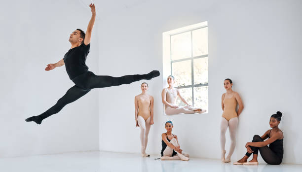 scatto completo di un gruppo eterogeneo di studenti di balletto che provano nel loro studio di danza - dancer jumping ballet dancer ballet foto e immagini stock