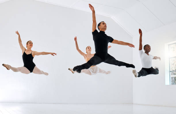 full length shot of a diverse group of ballet students rehearsing in their dance studio - dancer jumping ballet dancer ballet imagens e fotografias de stock