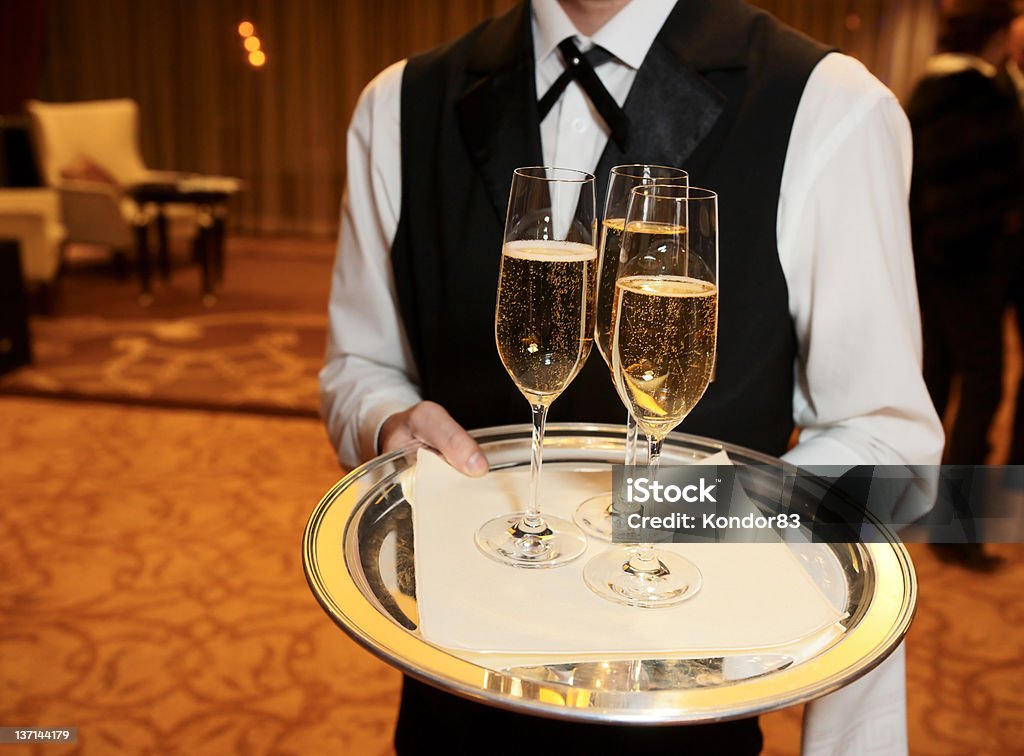 Male waiter with champagne flutes Waiter welcomes guests with champagne Adult Stock Photo