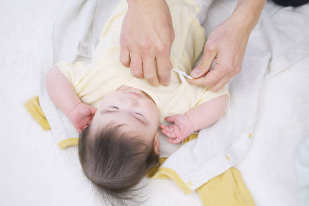 istock Asian dad changing baby clothes 1371445075
