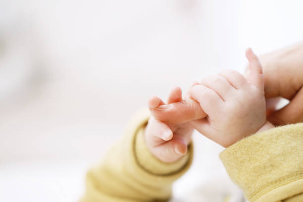 istock Asian baby holding mom's finger 1371445107