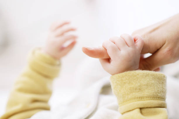 istock Asian baby holding mom's finger 1371445120