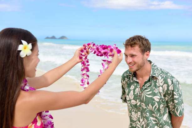 Hawaii woman giving lei garland welcoming tourist Hawaii woman giving lei garland of pink orchids welcoming tourist on Hawaiian beach. Portrait of a Polynesian culture tradition of giving a flower necklace to a guest as a welcome gesture. hula dancing stock pictures, royalty-free photos & images