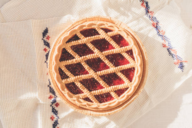 istock Top view of cherry pie on white table and rustic cloth at home 1371446737