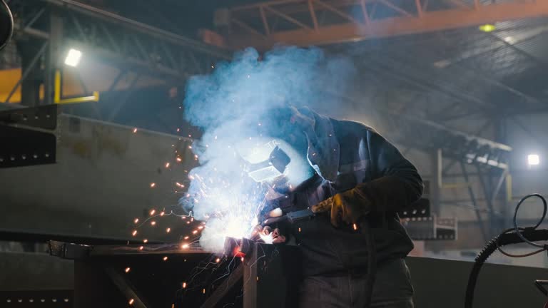 Industrial Welder With Torch in big hall welding metal profiles