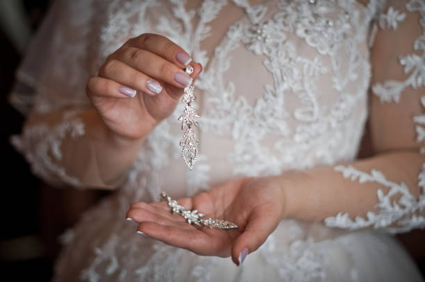 istock The bride is holding beautiful earrings in her hands 3168. 1371448383