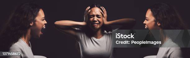 Shot Of A Young Woman Experiencing Mental Anguish And Screaming Against A Black Background Stock Photo - Download Image Now
