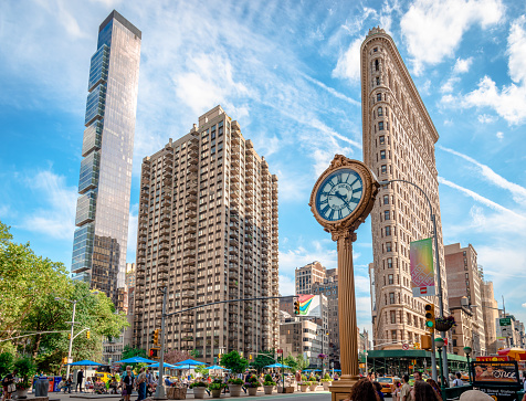 New York City, NY, USA - July 16 2014: View of One Madison building, Flatiron Building and the cast-iron sidewalk clock outside the Toys Center in Madison Square, Manhattan.