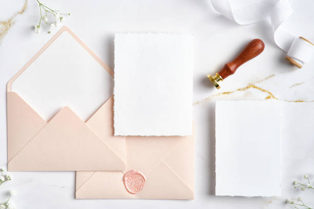 istock Elegant wedding stationery set. Flat lay pastel pink envelopes, blank wedding invitation cards mockups, silk ribbon, flowers on marble desk. 1371464355