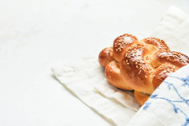 istock Challah bread. Sabbath kiddush ceremony composition. Freshly baked homemade braided challah bread for Shabbat and Holidays on white background, Shabbat Shalom. Top view. Copy space. 1371466400