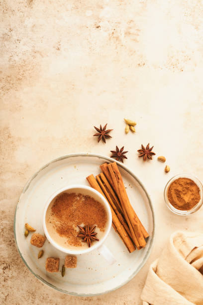 masala tee. masala chai gewürzter tee mit milch und gewürzen auf hellwarmem beigem hintergrund. traditionelles indisches getränk. gewürztee. speicherplatz kopieren. draufsicht. - star anise stock-fotos und bilder