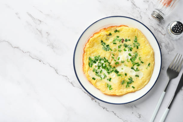 istock Omelette or frittatas with green onions or young greenery and mozzarella on white marble table background. Healthy food concept. Breakfast. Copy space. Top view. Mock up. 1371467297