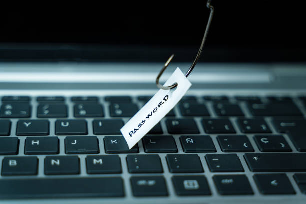 Fishhook stealing a piece of paper with the word Password on it on top of a laptop keyboard stock photo
