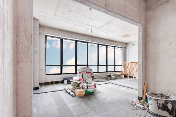 istock Reconstruction home. Building construction interior site with white concrete walls and blue claudy sky background view from the large window. 1371471060