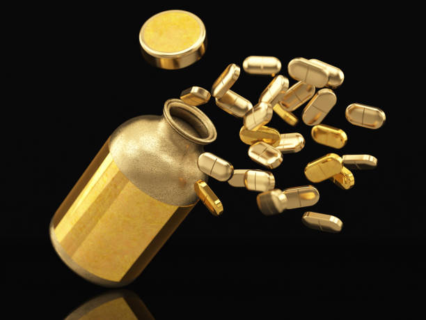 goldene flasche mit pillen auf schwarz - body care isolated objects medicine and science isolated on black stock-fotos und bilder