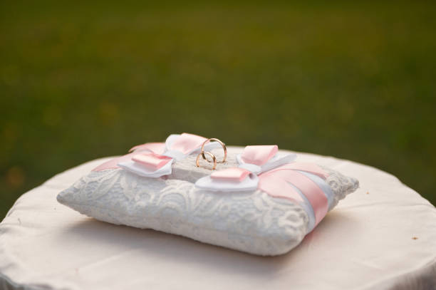 Pink and white pillow for wedding rings.