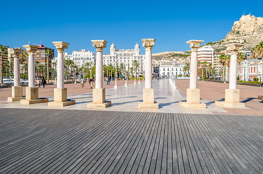 Alicante, Spain - December 30, 2018: Cityscape of Alicante from the seafront, with architectural columns in the foreground