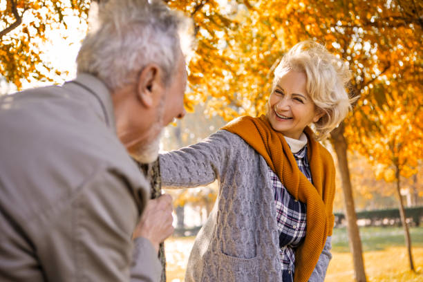 istock Senior couple in park chasing around tree 1371482252