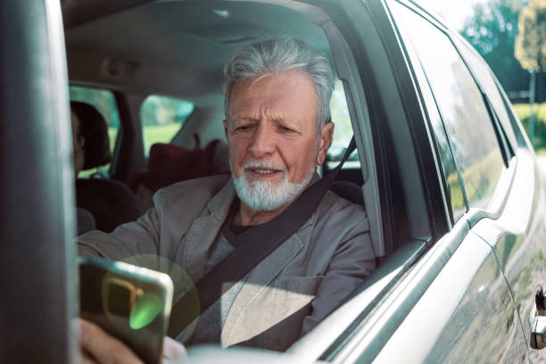 istock Senior with smartphone in car 1371482508