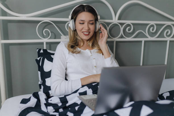 istock Young woman is using laptop in bed 1371482513