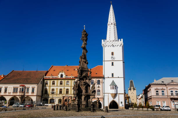 Holy Trinity Column with baroque sculptural group, Main town Peace square, gothic city hall tower, Medieval renaissance historical buildings, Mikulov Gate, Kadan, Czech Republic, April 04, 2021