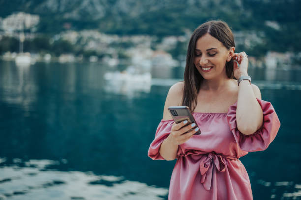 istock Woman using smartphone while walking on the city streets on the coast 1371487005