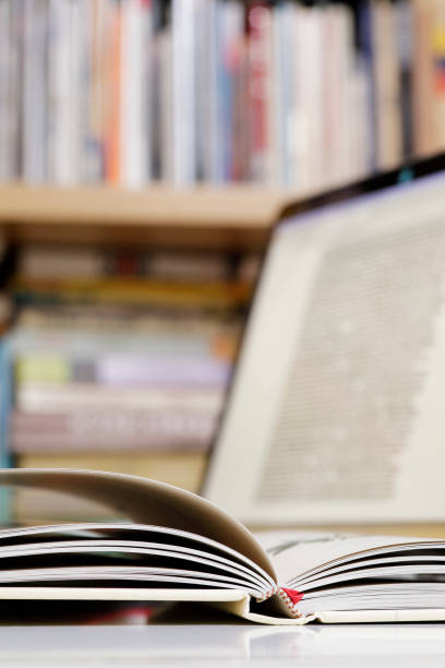 istock Close up of open book and  laptop computer at the library 1371496218