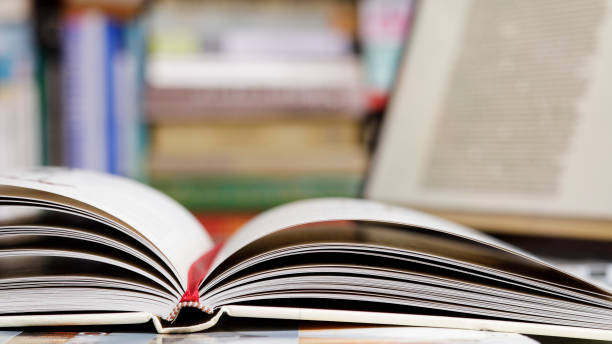 istock Close up of open book and  laptop computer at the library 1371496490