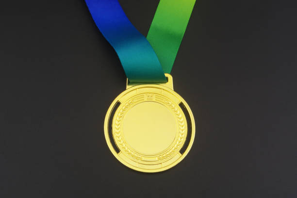 Gold medal with multicolored ribbon on black background