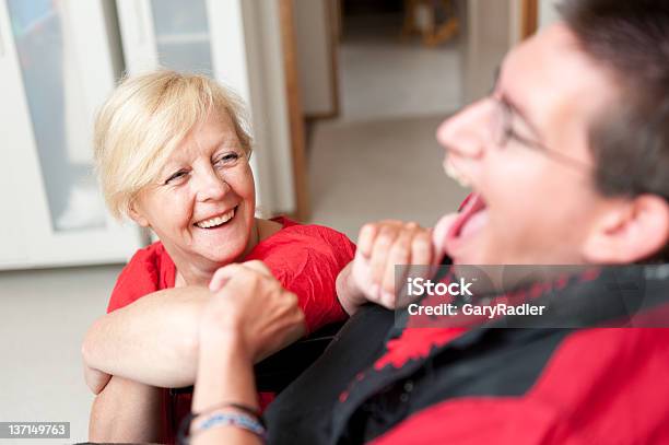 Disability Support Worker Looking Up At A Man Stock Photo - Download Image Now - Home Caregiver, Occupation, Adult