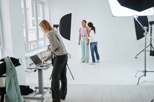 istock Make-up artist working during photo session while preparing look for her multiracial model 1371501027