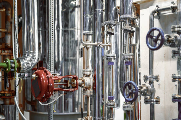 istock Thin metal pipes with small blue valves and flanges at plant 1371502725