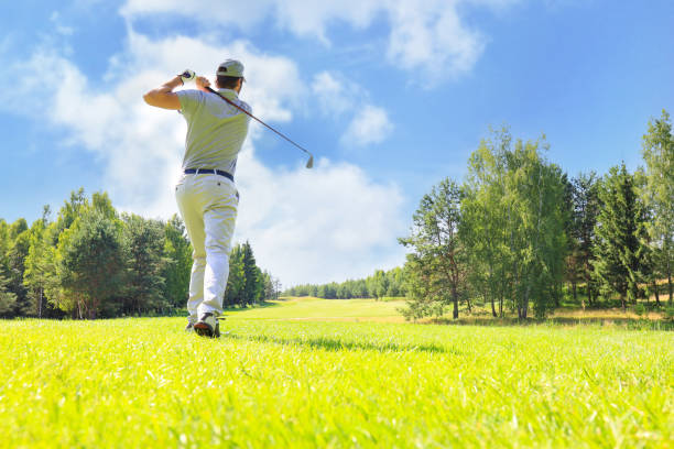 полная длина игры в гольф в солнечный день. профессиональный мужчина-гольфист, снимаемый на поле для гольфа. - golf swing golf teeing off men стоковые фото и изображения